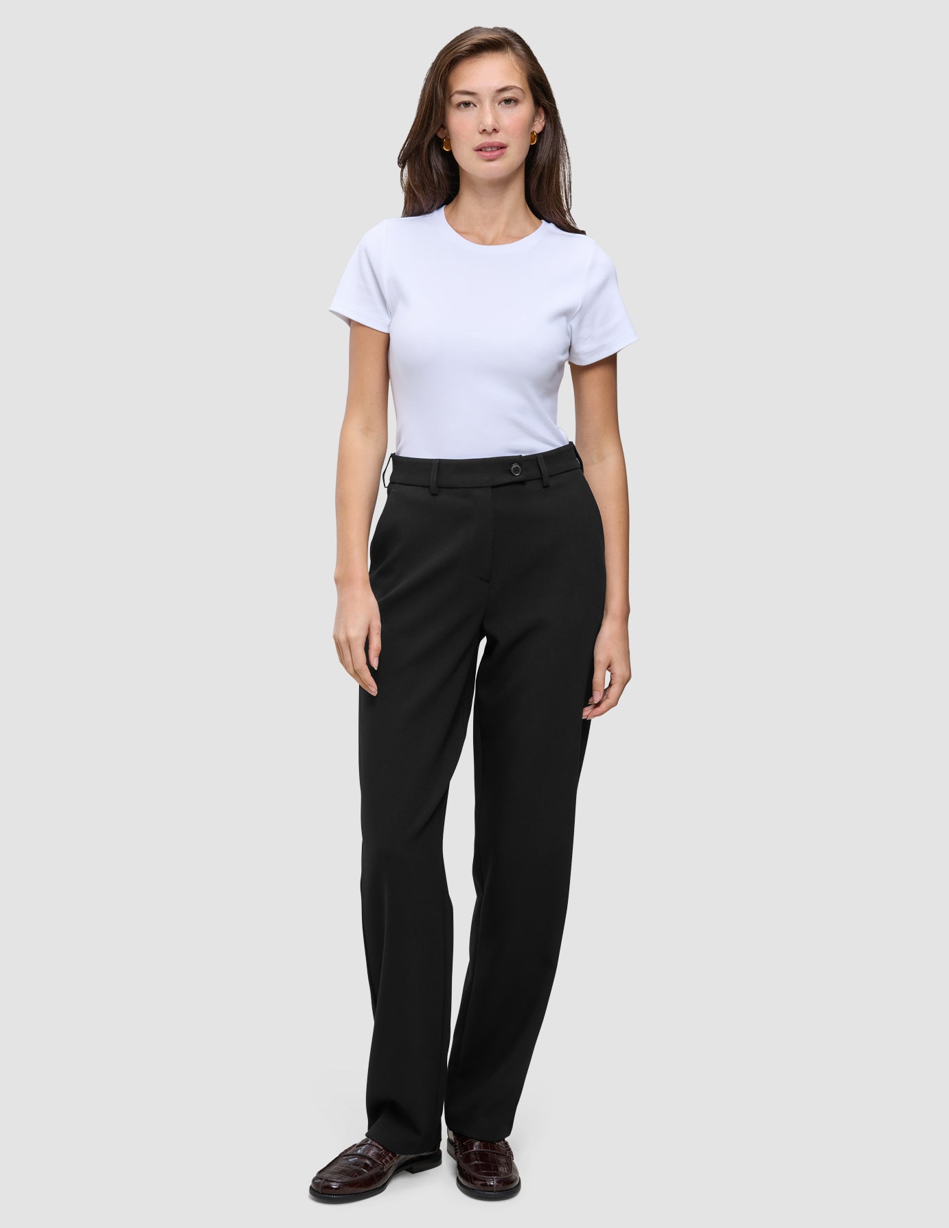En kvinne iført en hvit T-skjorte og Women GO2 Pants Straight Black med rette ben.
